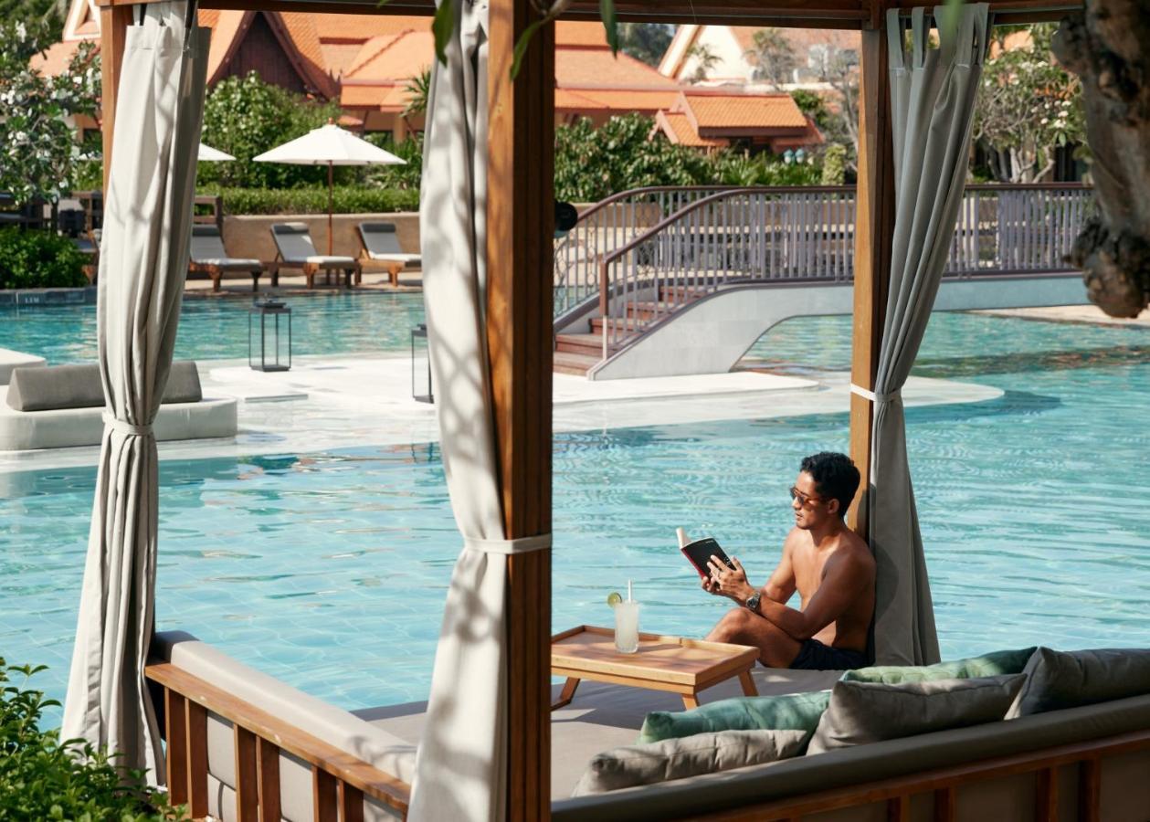 Dusit Thani Hua Hin Csaam Kültér fotó A man using a tablet at a resort